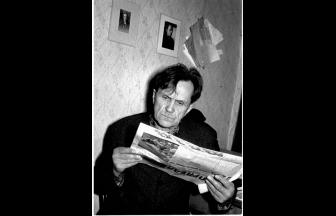 Shalamov reading a newspaper. On the wall are pictures of Osip Mandelstam. 1968. Photo: shalamov.ru